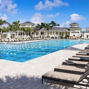 A swimming pool with lounge chairs and palm trees. - Heated salt water-pool & spa, walk to local beach, park, boat ramp, restaurants. (North Palm Beach)