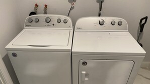 A laundry room with two white Whirlpool washers and dryers.