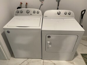 A laundry room with two white Whirlpool washers and dryers.