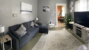 A living room with a grey sofa, a TV, and a fireplace.