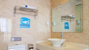 Ein Badezimmer mit Toilette, Waschbecken mit Spiegel darüber und Handtuchhalter.