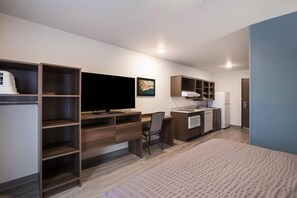 Una kitchenette moderna con horno empotrado, refrigerador y pileta.