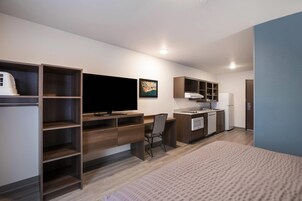 Una kitchenette moderna con horno empotrado, refrigerador y pileta.