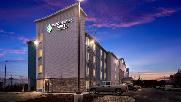 A multi-story hotel with a prominent sign reading "Woodspring Suites." - WoodSpring Suites Detroit Madison Heights (Madison Heights)