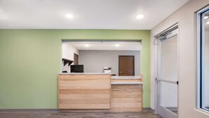 A modern kitchen with a wooden countertop, built-in cabinets, and a microwave. - WoodSpring Suites Detroit Madison Heights (Madison Heights)
