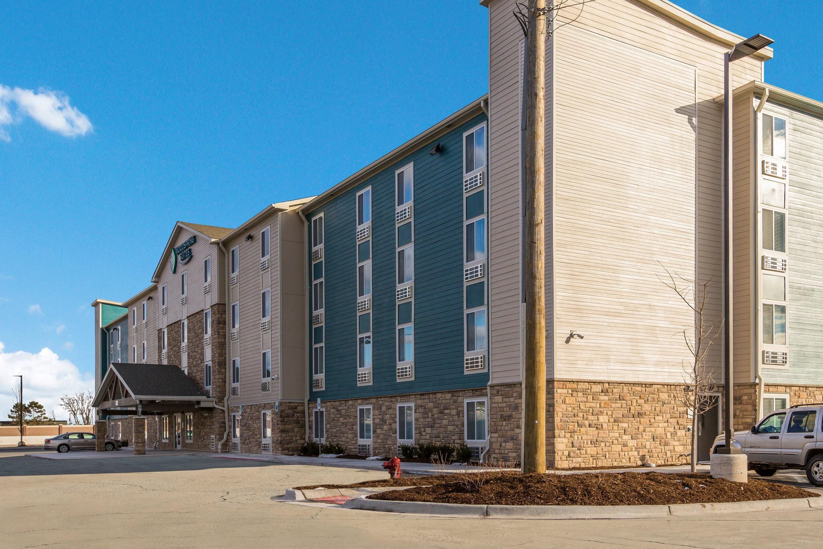 A multi-story hotel with a flat roof, a parking lot, and a fire hydrant.