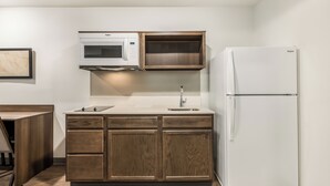Una cocina equipada con microondas, lavaplatos y refrigerador.