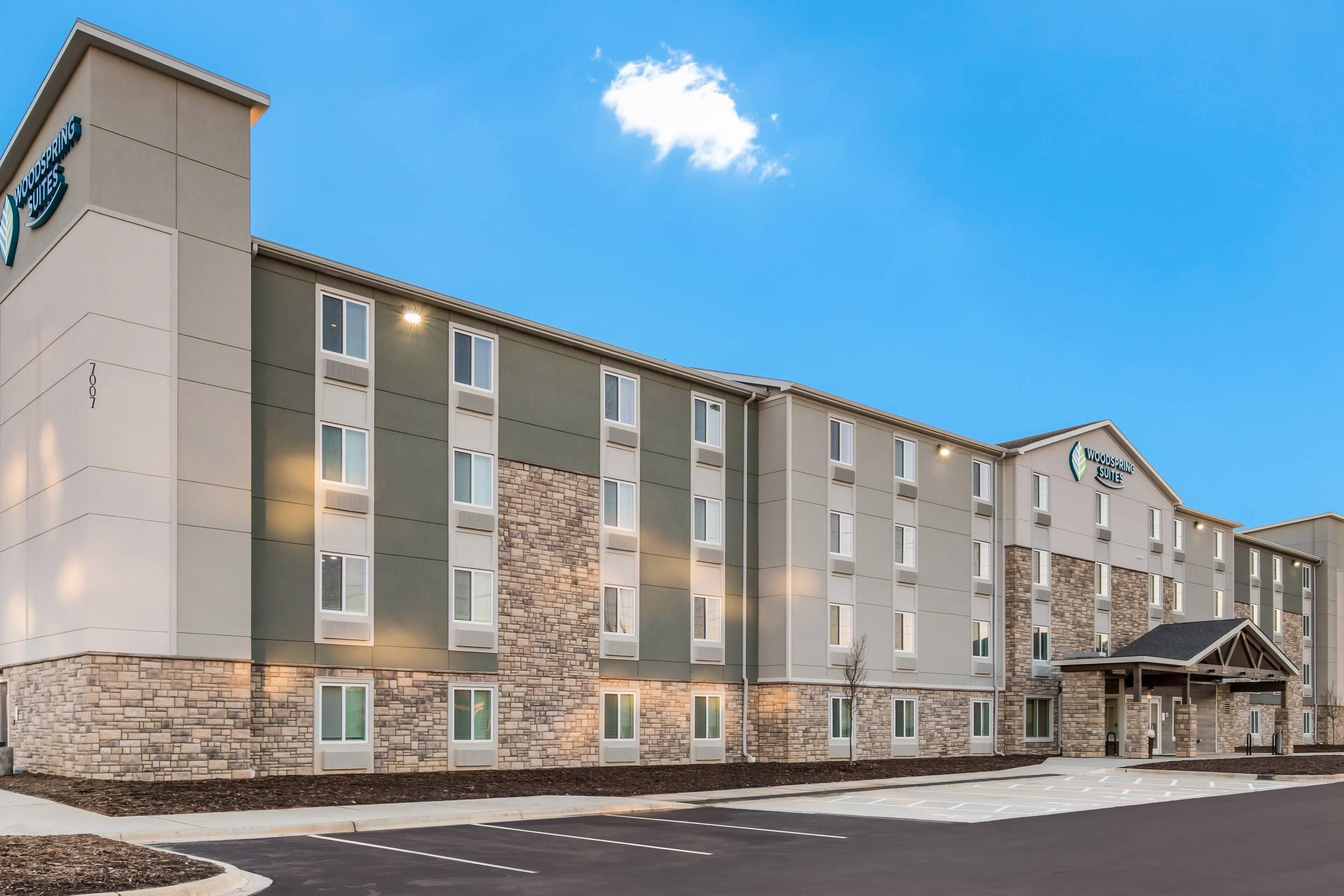 A multi-story hotel with a stone facade and a flat roof.