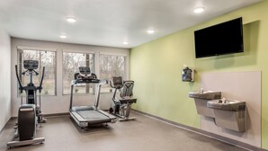Un gimnasio con cintas de correr, una bicicleta estática y una máquina de remo.