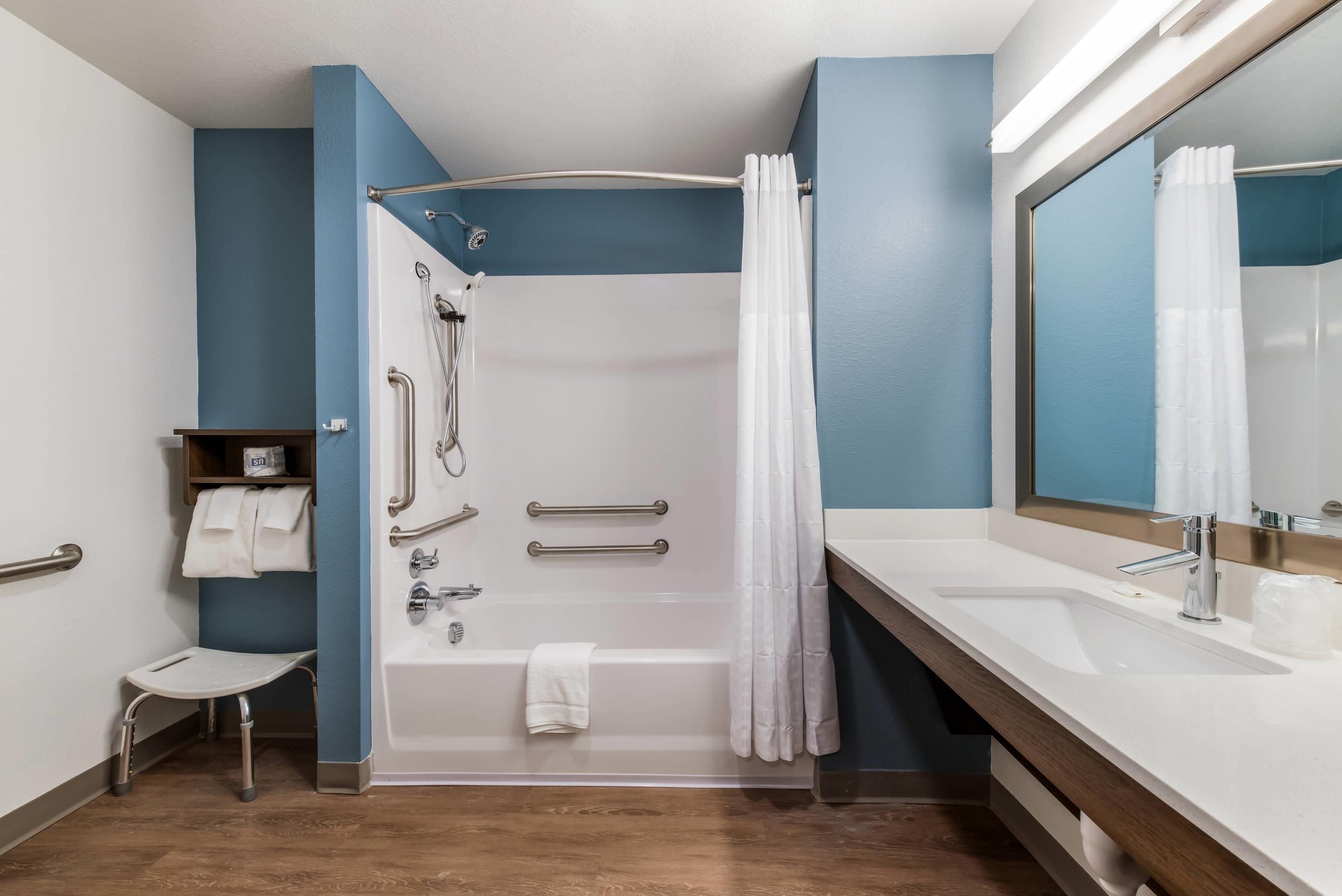 A modern bathroom with a bathtub, shower, and dual sinks.