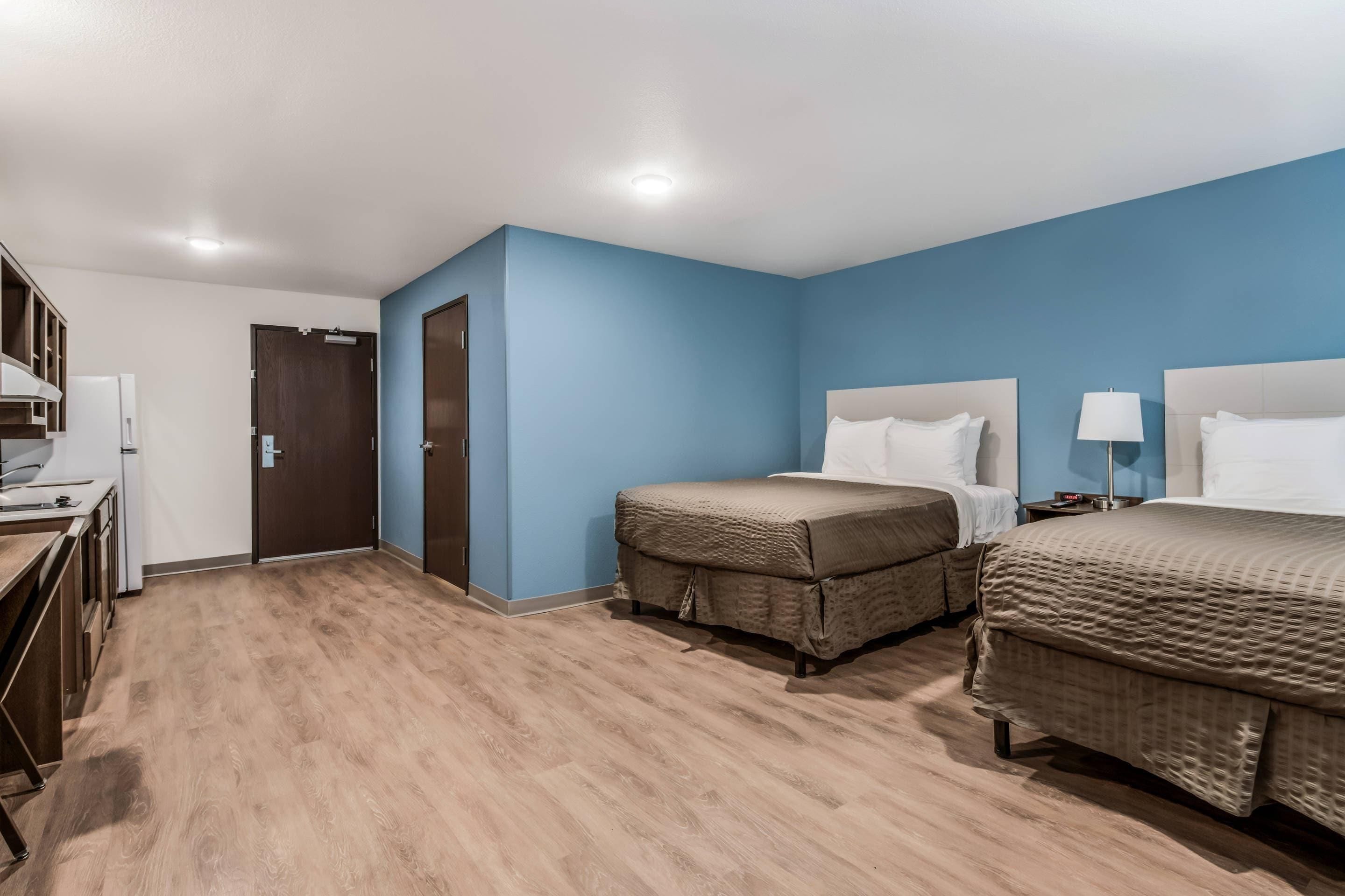 Une chambre d’hôtel avec deux lits, un bureau et une armoire.