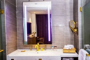 A modern bathroom with a large mirror, a vanity with a yellow faucet, and a wooden tray holding towels. - James Joyce Coffetel Shanghai Hongqiao Hub National Convention and Exhibition Center (Shanghai)