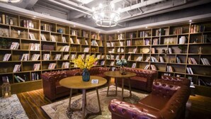 Eine Bibliothek mit Ledersofas, Bücherregalen und einem Kronleuchter.