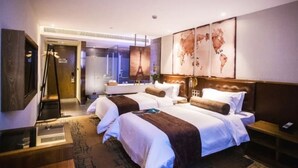 Ein Hotelzimmer mit zwei Betten, einer großen Weltkarte an der Wand, einer Minibar und Blick auf den Flur.