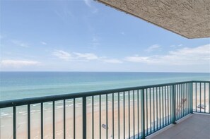Un balcon avec vue sur la plage et l’océan.