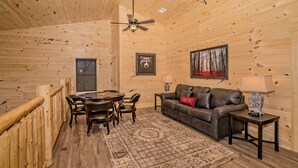 A wooden interior with a dining table, chairs, a sofa, and a ceiling fan. - 11 Miles to Gatlinburg! Indoor Heated Pool/Theater Room/Hot Tub/ DISCOUNTS! (Sevierville)