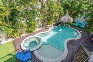 A swimming pool with a hot tub, surrounded by palm trees and lounge chairs. - Portside Paradise (Holmes Beach)