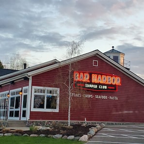 A red building with a neon sign reading "BAR HARBOR SURPER CLUB" and a list of food items below. - Waterfront Cabin on Gull Lake w/ Boat Rentals (Nisswa)