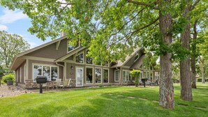 Une maison à deux étages, dotée d’un grand porche à l’avant, de fondations en pierre et d’une pelouse bien entretenue.