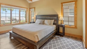 Une chambre à coucher avec un grand lit, des poutres en bois et un ventilateur de plafond.