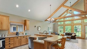 Una cocina amplia con armarios de madera, una isla central y un ventanal que proporciona luz natural.