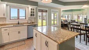 A spacious kitchen with a large island, white cabinetry, and a view to the outdoors. - Lakeside Comfort in the Heart of Gull Lake, Beach Access, Boat Rentals (Nisswa)
