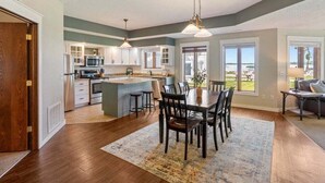 A spacious kitchen with a dining area, large windows, and a view of the outdoors. - Lakeside Comfort in the Heart of Gull Lake, Beach Access, Boat Rentals (Nisswa)