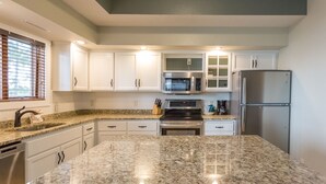 A kitchen with white cabinets, a granite countertop, stainless steel appliances, and a dishwasher. - Gull Lake at Your Doorstep |Waterfront Rental | Sleep 8 (Nisswa)