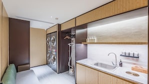 Una cocina compacta con electrodomésticos integrados, un lavamanos y una pequeña zona de estar.