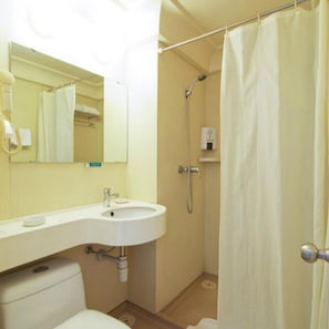 A bathroom with a toilet, sink, and shower.