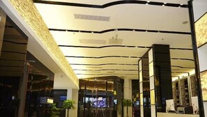 A spacious lobby with a high ceiling, a central seating area, and a reception desk. - Lavande Hotel (Tianjin)