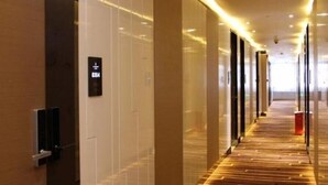 A modern hotel corridor with a wooden floor, glass walls, and a sign indicating room number 8304. - Lavande Hotel (Tianjin)