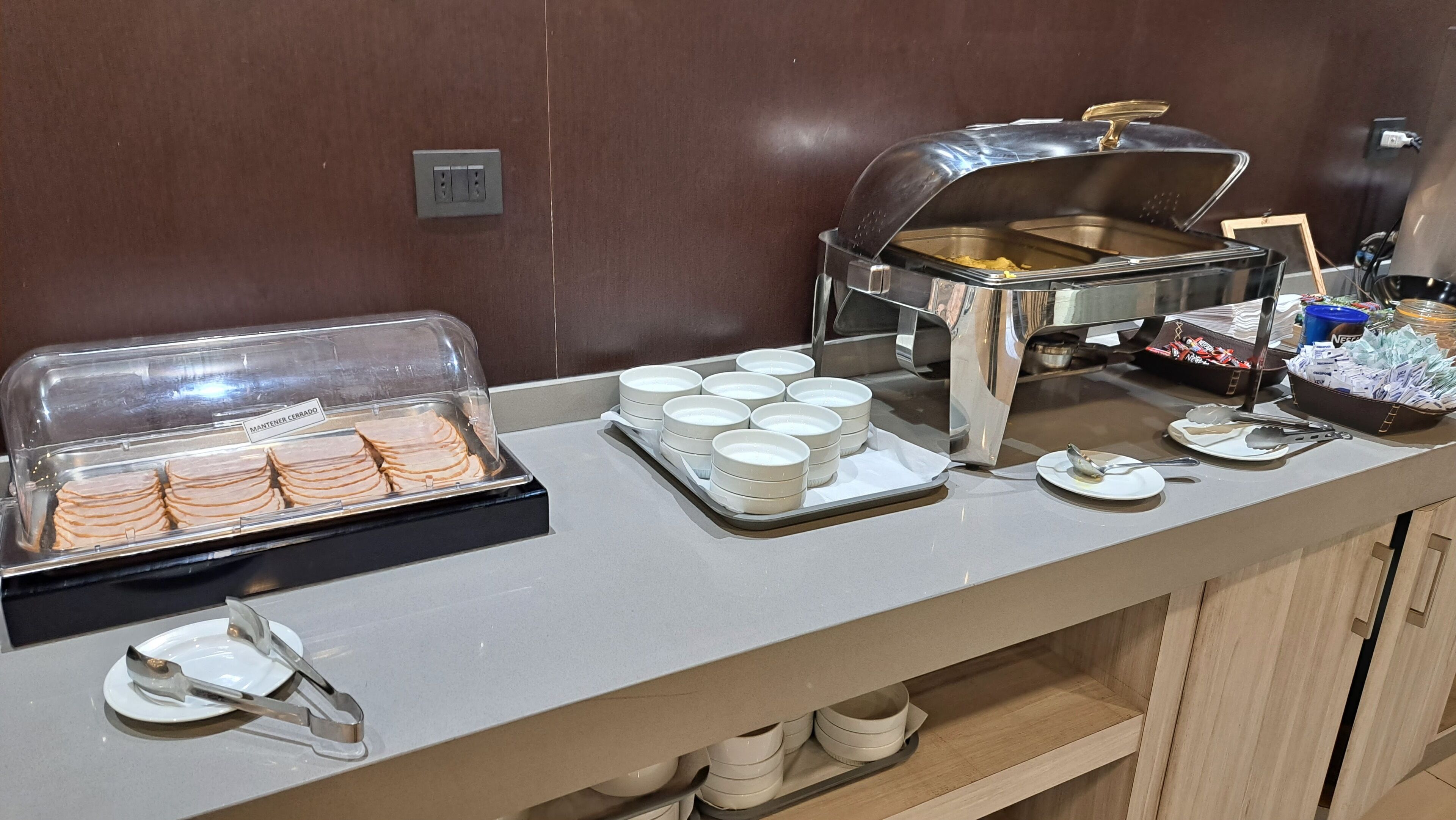 Un buffet proposant une variété de plats et d’ustensiles de service.