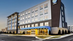 A modern hotel with a prominent 'TRU by Hilton' sign, featuring a large entrance with a covered area, multiple floors, and a parking lot in front. - Tru by Hilton Franklin Cool Springs Nashville (Franklin)
