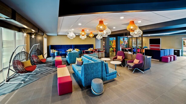A modern hotel lobby with blue seating areas, hanging lamps, and a reception desk. - Tru by Hilton Franklin Cool Springs Nashville (Franklin)