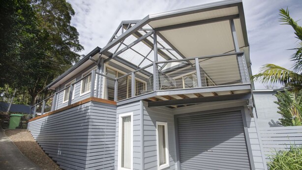 A two-story house with a balcony, a garage, and a covered driveway. - "Happy Ours" - Walking Distance to Shops & Beach (AVOCA BEACH)