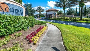 A sign for LTERRA RESORT with a pathway leading to a building, surrounded by greenery and palm trees. - Enchanting!! 6 Bed 5 Bath House With Pool 1880 (Davenport)