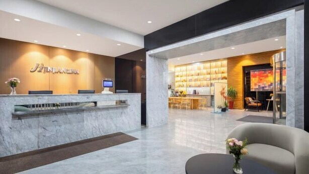 A modern hotel lobby with a reception desk, seating area, and a dining space. - Jinjiang Inn (Weihai High-speed Railway North Station Oulefang Commercial Street Hotel) (Weihai)