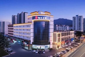 Un hôtel à plusieurs étages, doté d’une façade incurvée remarquable, d’un parking et situé dans un cadre montagneux.