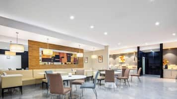A modern dining area with a central round table, multiple seating options, and contemporary decor.