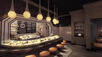 Uma área de bar com exposição de frutos do mar, banquetas e luminárias pendentes.