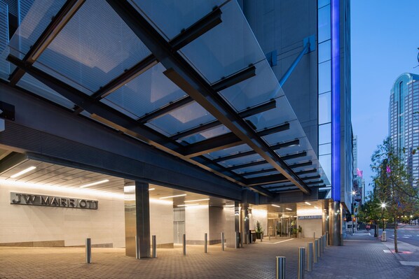 A JW Marriott hotel entrance with a modern glass facade, a brick-paved entrance area, and a clear view of the surrounding urban environment. - JW Marriott Charlotte (Charlotte)