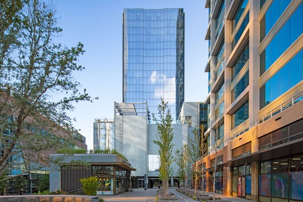 A modern hotel with a glass facade, a brick base, and a courtyard with trees. - JW Marriott Charlotte (Charlotte)