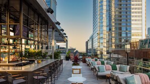 A rooftop bar with a bar counter, seating area, and potted plants. - JW Marriott Charlotte (Charlotte)