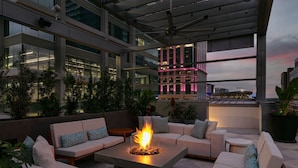 A rooftop lounge with a fire feature, seating, and a view of the city skyline. - JW Marriott Charlotte (Charlotte)