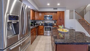 A modern kitchen with stainless steel appliances, wooden cabinets, and a granite countertop. - WOW! Hikers/Bikers/Golfers PARADISE, Pvt Htd POOL, Putt Green, Tesla Charger (Gilbert)