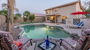 A backyard with a swimming pool, patio furniture, and a house. - WOW! Hikers/Bikers/Golfers PARADISE, Pvt Htd POOL, Putt Green, Tesla Charger (Gilbert)