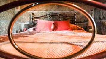 A bed with a headboard, pillows, and a blanket.
