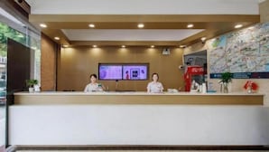 A reception desk with two staff members, a digital display, and a map on the wall. - Greentree Inn Jiaxing Tongxiang Tudian Express Hotel (Jiaxing)