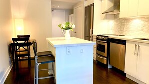 Una cocina moderna con una isla central, electrodomésticos de acero inoxidable y un salpicadero blanco.